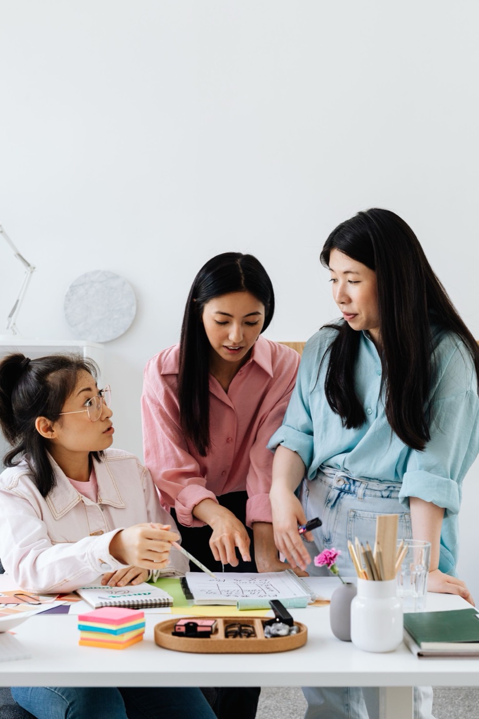 Three women discussing around a table